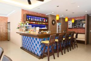 芭东海滩古德耐斯酒店的餐厅设有酒吧,配有木凳