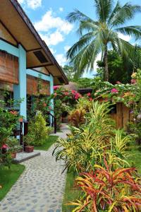 爱妮岛Angel Nido Resort的一座种植了植物的花园,旁边是一条人行道