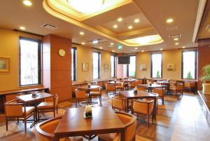 盐尻市盐尻市鹿特因酒店的一间在房间内配有桌椅的餐厅