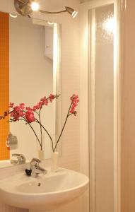 巴塞罗那MH里瑟欧公寓式酒店的浴室设有水槽,花瓶里装有鲜花