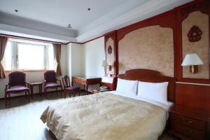 基隆华都饭店 的酒店客房带一张床、一张桌子和椅子