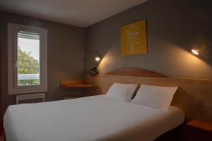 拉沙佩勒圣梅曼KYRIAD DIRECT Orleans - La Chapelle St Mesmin的卧室配有白色的床和窗户。
