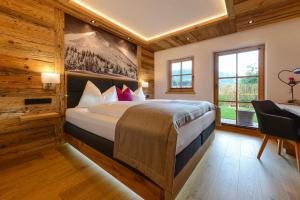 戈尔德格Gams Lodge的一间带一张大床的卧室,位于带木墙的房间