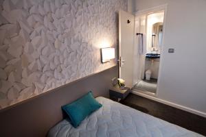 里昂让博斯科中心酒店的卧室配有一张大墙的白色纸