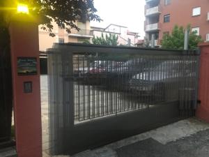 阿尔巴Casa Soave B&B的停车场的大门,后面有汽车