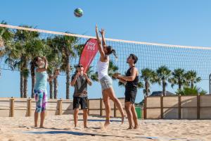 普雷塔斯Playitas Aparthotel - Sports Resort的一群人在沙滩上打排球