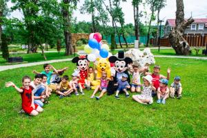 雅罗斯拉夫尔Kremnievy Termy Spa Complex的一群坐在草地上,带着吉祥物的孩子