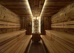 什平德莱鲁夫姆林Wellness Hotel Astra的空空的桑拿浴室铺有木地板,设有木墙