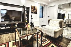 蒙特利尔Cosy apartment at Bossuet road的客厅配有电视、椅子和玻璃桌
