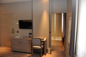 奥德纳尔德德萨尔蒙酒店的客房设有书桌、椅子和电视。