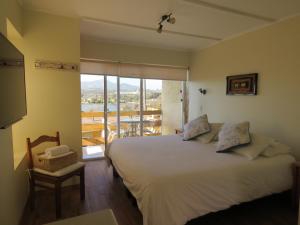 康康里奥马尔阿帕特酒店的一间带大床的卧室和一个阳台