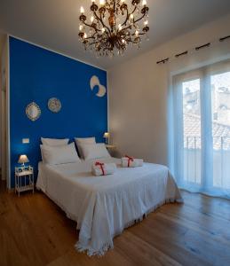 弗拉斯卡蒂B&B Buonfiglio Cicconcelli - Terrazza panoramica的一间卧室配有一张白色大床和蓝色的墙壁