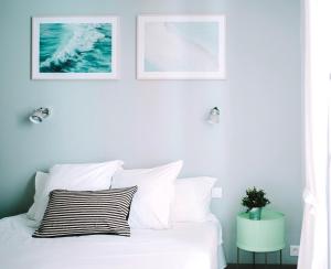 比亚里茨Outsite Coliving Biarritz的卧室配有一张白色床,墙上挂有两张照片