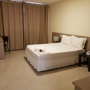 Paracambi帕拉坎比顶级酒店的卧室配有一张白色大床,上面有蜡烛