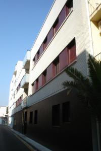 普拉加德阿罗阳光阿波罗酒店的白色的建筑,在街上有红色的窗户