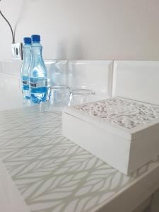 罗兹努公寓式酒店的一张床垫和桌子上的两瓶水