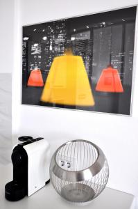 阿尔盖罗三角帆度假酒店的一张烤面包机和一张桌子上的花瓶,旁边是一张照片