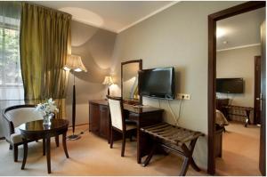 奥布宁斯克Greenway Park Hotel的酒店客房设有电视和带镜子的书桌