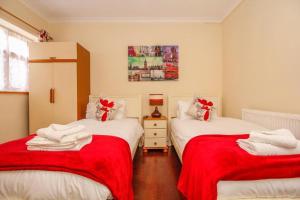 牛津哈里斯旅馆的配有红色和白色床单的客房内的两张床