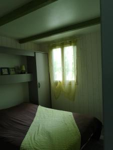 Le Mée杜浅眉木屋度假屋的一间卧室设有一张床和一个窗口