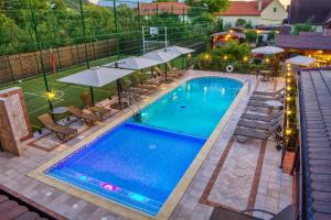 克里斯蒂安蔻娜奇奥安比恩特度假酒店的享有带椅子和遮阳伞的游泳池的上方景色