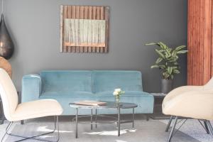 安德诺莱斯贝恩L'Anderenis Boutique Hôtel的客厅配有蓝色的沙发、两把椅子和一张桌子