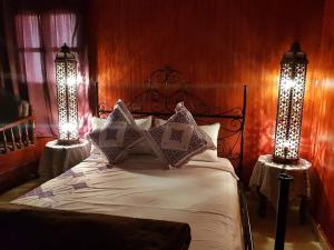 穆莱伊德里斯Kasabah Senhaji的一间卧室配有一张带两个灯的床