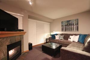 惠斯勒Sunpath Condos by Whistler Retreats的带沙发和壁炉的客厅