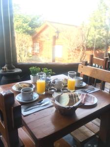埃尔卡拉法特索拉雷斯德尔苏尔山林小屋的一张带食物和橙汁的木桌