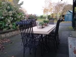 WilmotRobin's Nest B&B的庭院里摆放着桌椅和植物