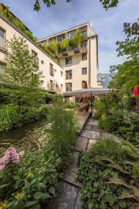 因斯布鲁克娜拉独立酒店的一座带花园的建筑,毗邻河流