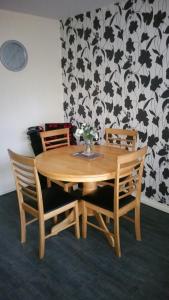 因弗内斯Lerwick Garden Apartment的一张带两把椅子的木桌和花瓶