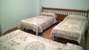 莱昂Hostal ** EC León的客房内的三张床,上面有白色的毯子