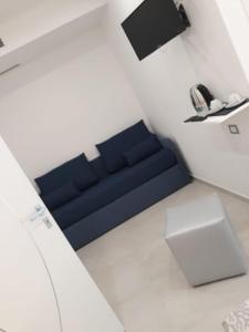 维耶斯泰Accanto a te - Charme Rooms的白色房间里一张蓝色的沙发