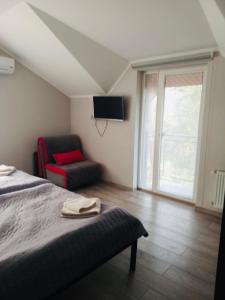 布留霍维奇Motozona的一间卧室配有一张床、一把椅子和电视