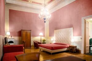 佛罗伦萨Hotel Bretagna Heritage - Alfieri Collezione的一间卧室配有一张红色的床和吊灯。