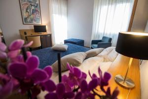 斯波莱托克拉丽奇酒店的客厅配有一张床和紫色鲜花