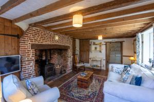 BridgePrimrose Cottage at The Shippe的客厅配有白色家具和砖砌壁炉
