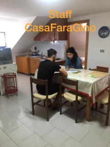 阿斯科利皮切诺Casa Fara Gino的坐在厨房桌子上的男女