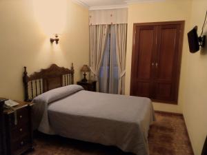 蒙蒂利亚贝利多旅馆的一间卧室配有一张床、一个梳妆台和一扇窗户。