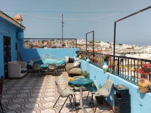 丹吉尔Hôtel Marrakech的阳台设有蓝色墙壁上的桌椅。