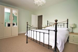 赫里福德Clifton House的一间卧室配有一张带白色床单和吊灯的床。