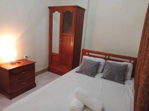 锡基霍尔Fontelo Bungalow Guest House的一间卧室配有一张带木制床头板和床头柜的床。