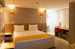 马塞约Comfort Hotel Maceió的配有一张床和一张书桌的酒店客房