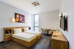 北尼科西亚G Suites Luxury Rentals的一间卧室配有一张床、一台电视和一张书桌