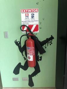 雅科Room2Board Hostel and Surf School的门上与持枪者一起的灭火器标志