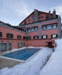 埃尔祖鲁姆德德曼帕兰朵肯滑雪旅舍酒店的一座在雪中设有游泳池的建筑