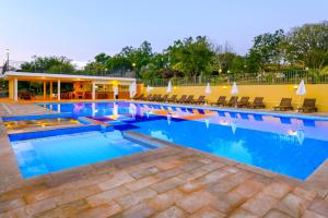 布罗塔斯Hotel Fazenda Areia que Canta的一个带椅子和蓝色水的大型游泳池