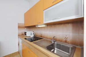 比奥格勒·纳·莫鲁Apartments Vedrana的厨房配有不锈钢盥洗盆和木柜