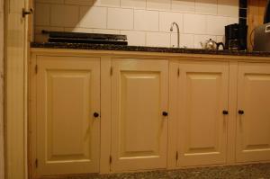 Hijken昂兹迪尔住宿加早餐旅馆的厨房配有白色橱柜和水槽